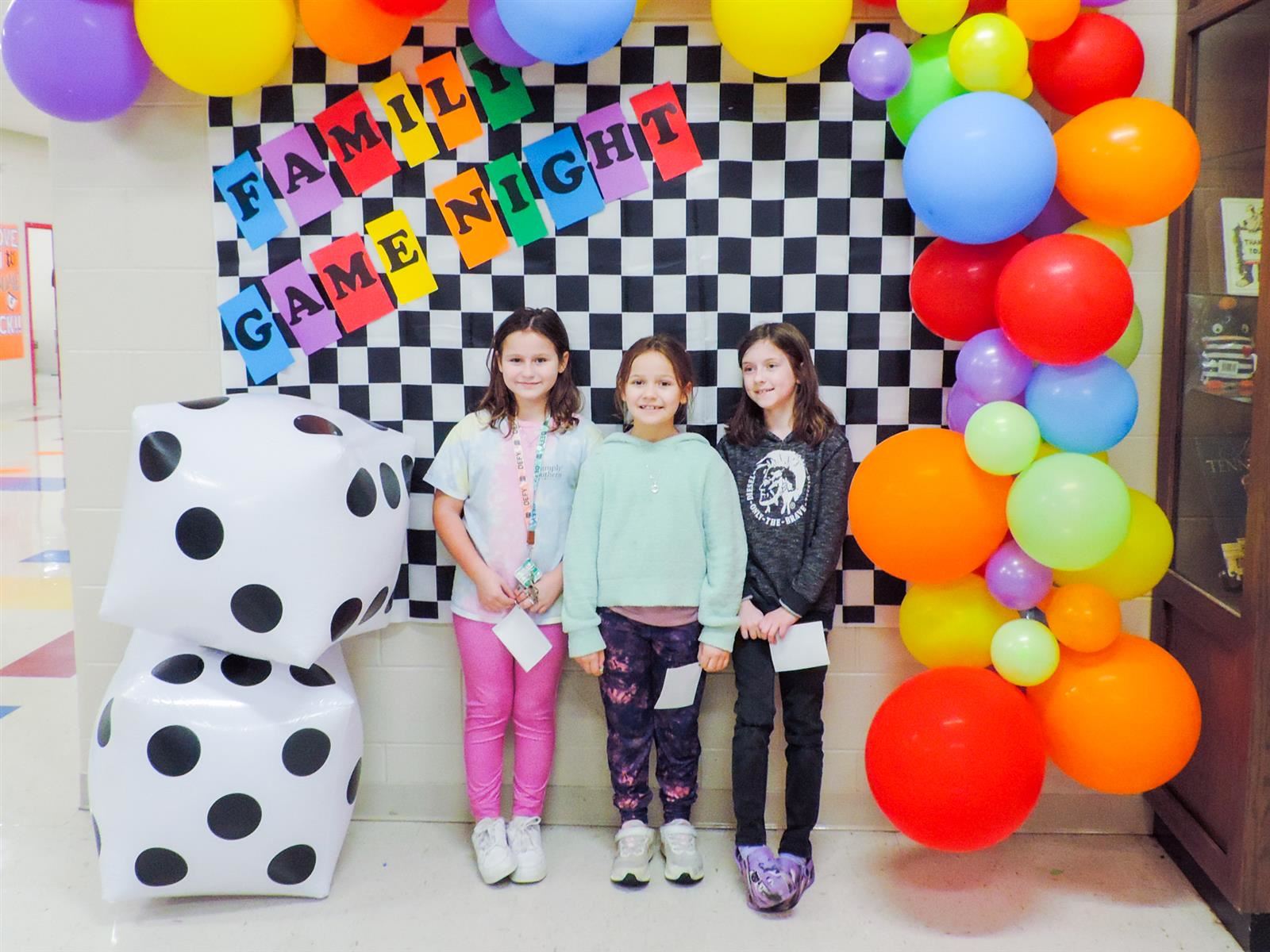 Three female students in front of a Family Night
